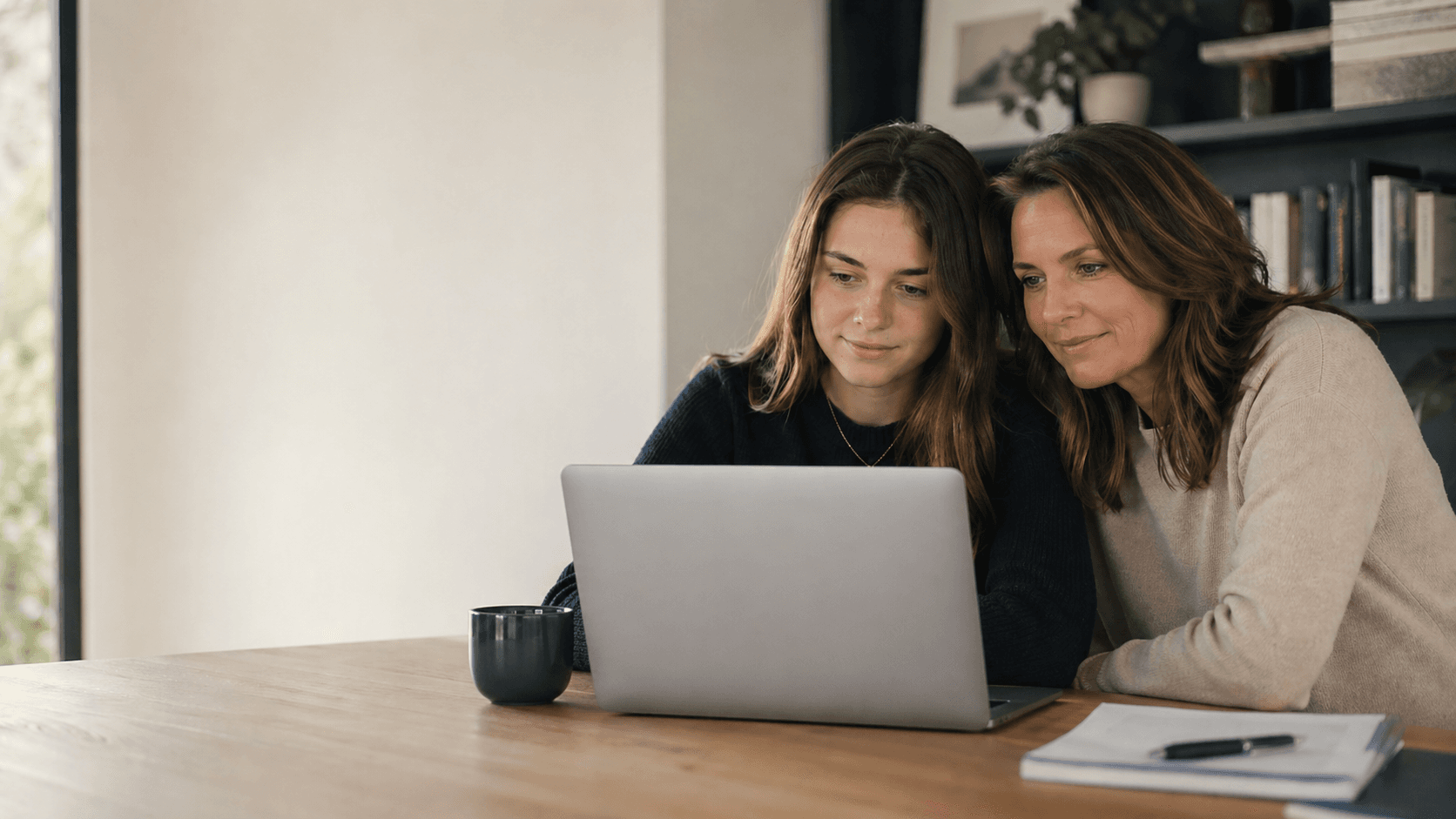 Mother and daughter reviewing college planning on a laptop